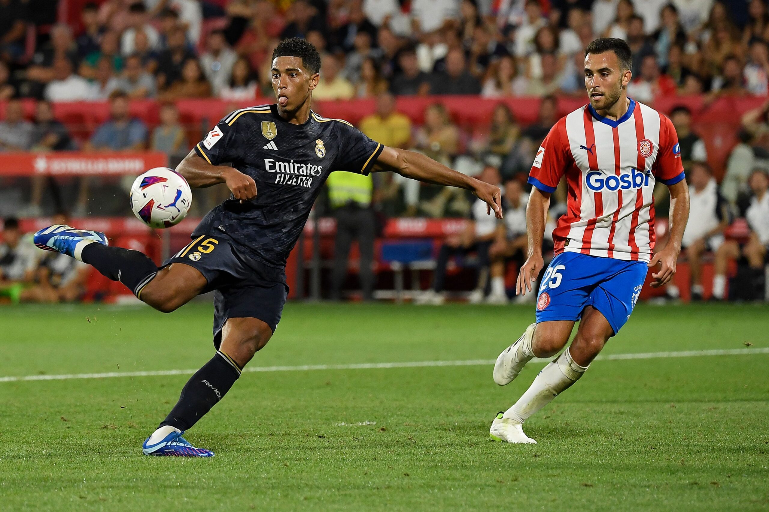 Real Madrid's English midfielder #5 Jude Bellingham kicks the ball and scores his team's third goal during the Spanish Liga football match between Girona FC and Real Madrid CF at the Montilivi stadium in Girona on September 30, 2023.