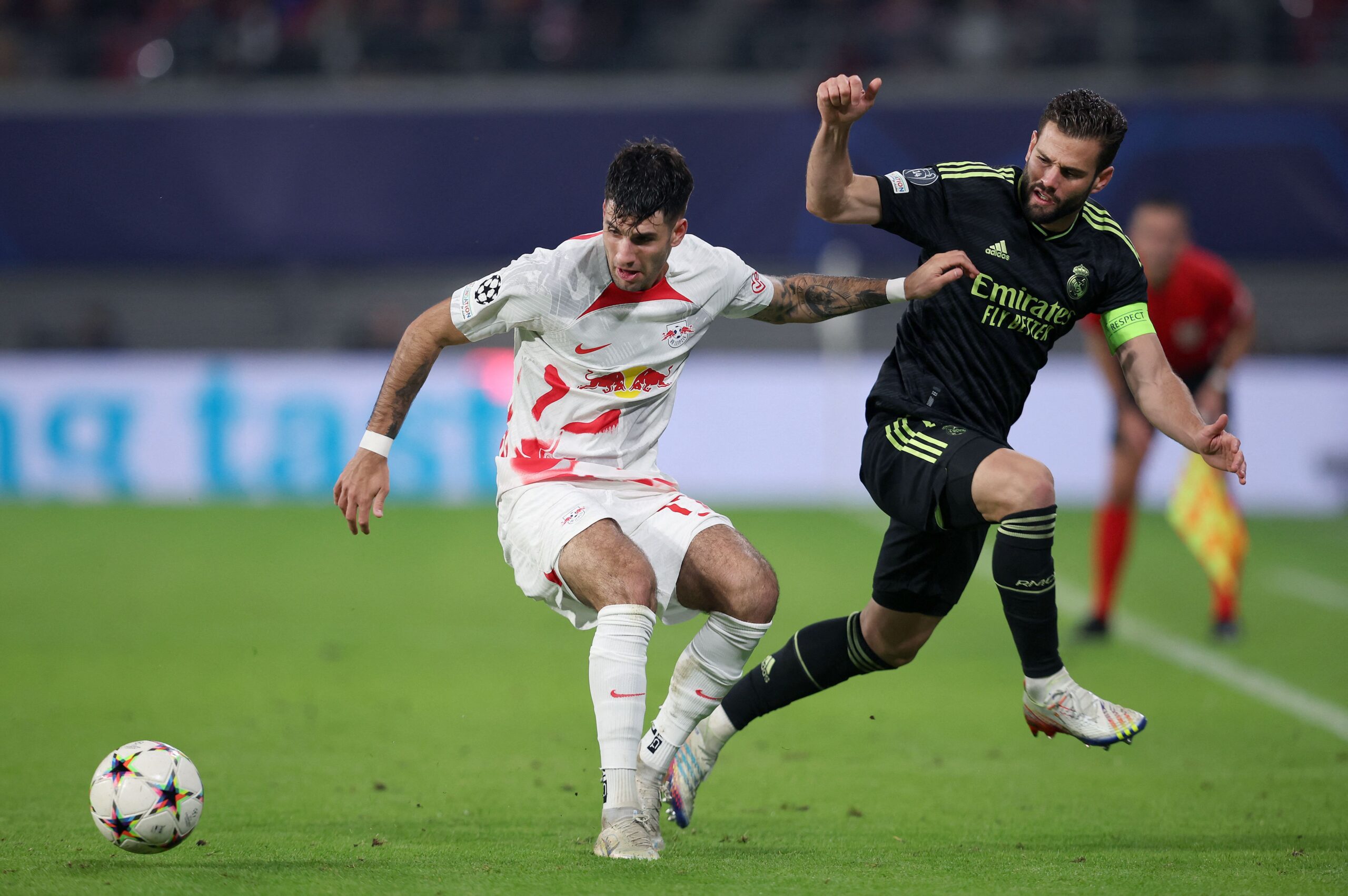 Leipzig's Hungarian midfielder Dominik Szoboszlai (L) vies for the ball with Real Madrid's Spanish defender Nacho Fernandez during the UEFA Champions League Group F football match between RB Leipzig and Real Madrid CF in Leipzig, eastern Germany on October 25, 2022.