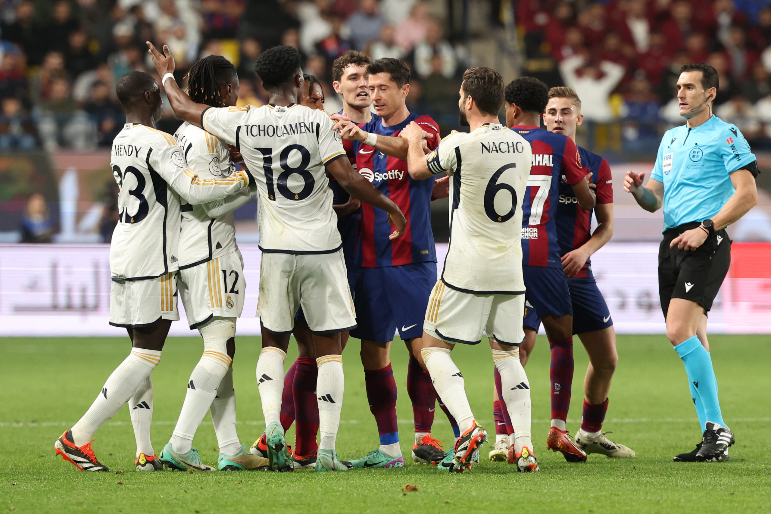 Spanish match referee Juan Martinez Munuera approaches as Barcelona's Polish forward #09 Robert Lewandowski and French defender #23 Jules Kounde argue with Real Madrid's French midfielder #12 Eduardo Camavinga and French defender #18 Aurelien Tchouameni during the Spanish Super Cup final football match between Real Madrid and Barcelona at the Al-Awwal Park Stadium in Riyadh, on January 14, 2024.