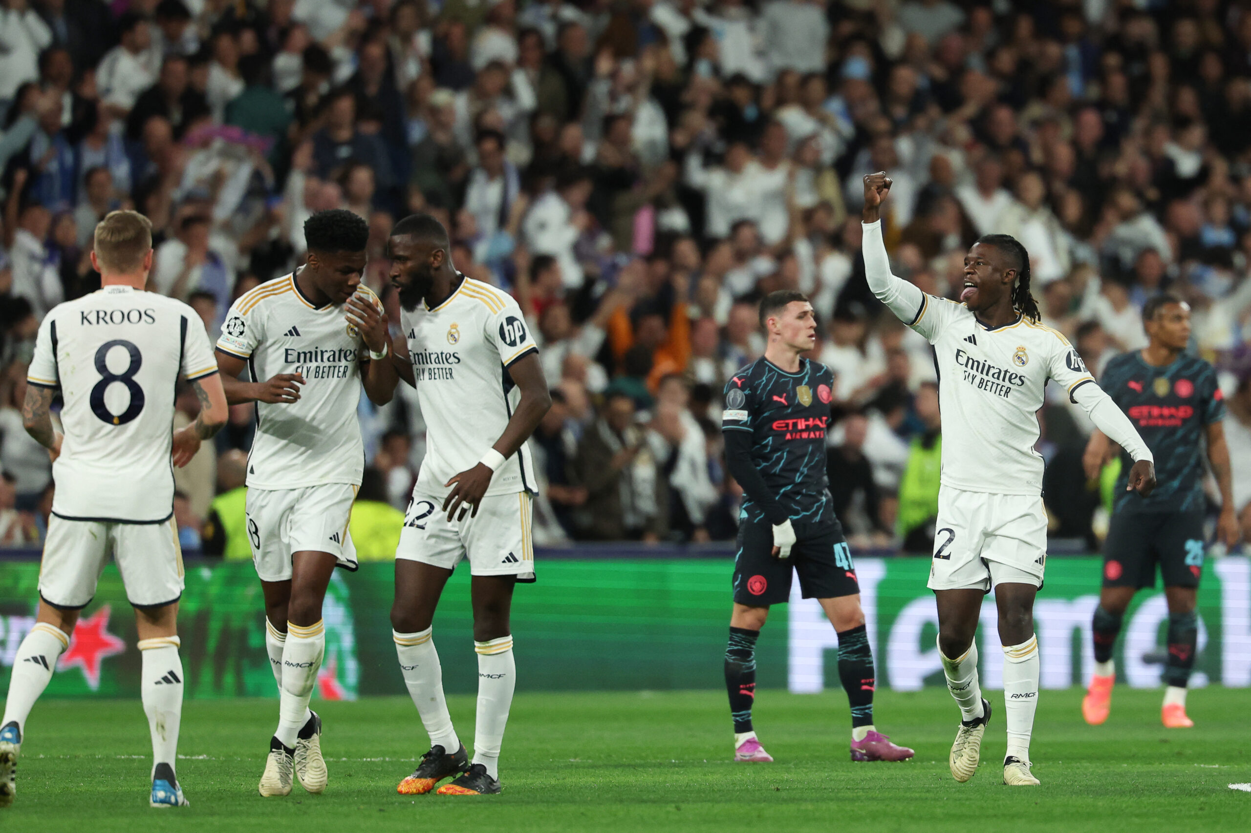 Real Madrid's French midfielder #12 Eduardo Camavinga (R) celebrates scoring his team's first goal during the UEFA Champions League quarter final first leg football match between Real Madrid CF and Manchester City at the Santiago Bernabeu stadium in Madrid on April 9, 2024.