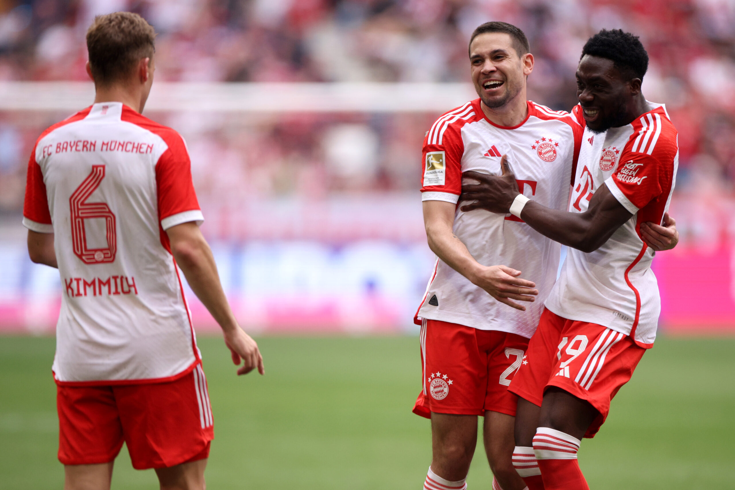 MUNICH, GERMANY - APRIL 13: Raphael Guerreiro of Bayern Munich celebrates scoring his team's first goal with teammates Joshua Kimmich and Alphonso Davies during the Bundesliga match between FC Bayern München and 1. FC Köln at Allianz Arena on April 13, 2024 in Munich, Germany.