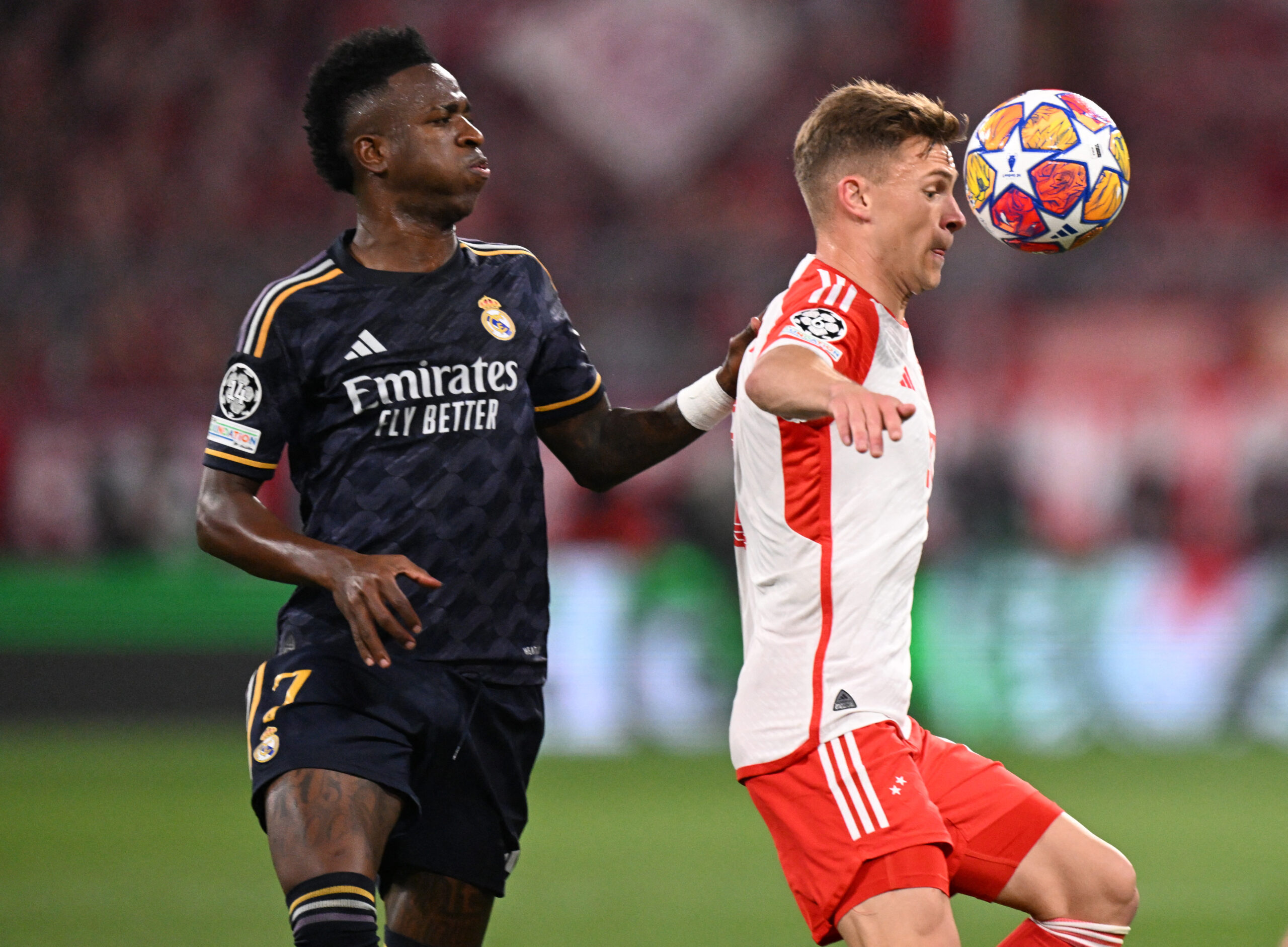Real Madrid's Brazilian forward #07 Vinicius Junior and Bayern Munich's German midfielder #06 Joshua Kimmich vie for the ball during the UEFA Champions League semi-final first leg football match between FC Bayern Munich and Real Madrid CF on April 30, 2024 in Munich, southern Germany.