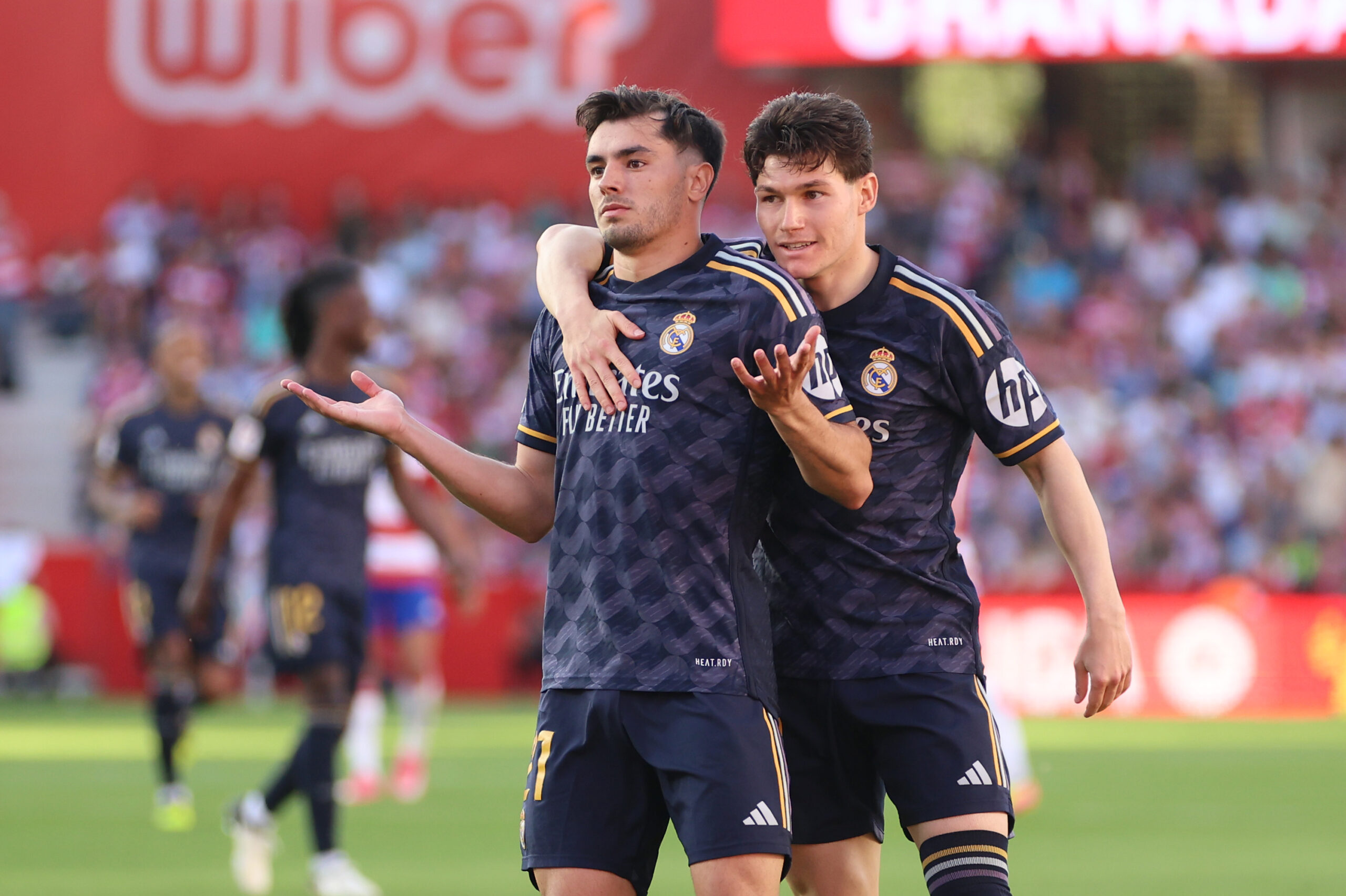 GRANADA, SPAIN - MAY 11: Brahim Diaz of Real Madrid celebrates scoring his team's fourth goal with teammate Fran Garcia during the LaLiga EA Sports match between Granada CF and Real Madrid CF at Estadio Nuevo Los Carmenes on May 11, 2024 in Granada, Spain.