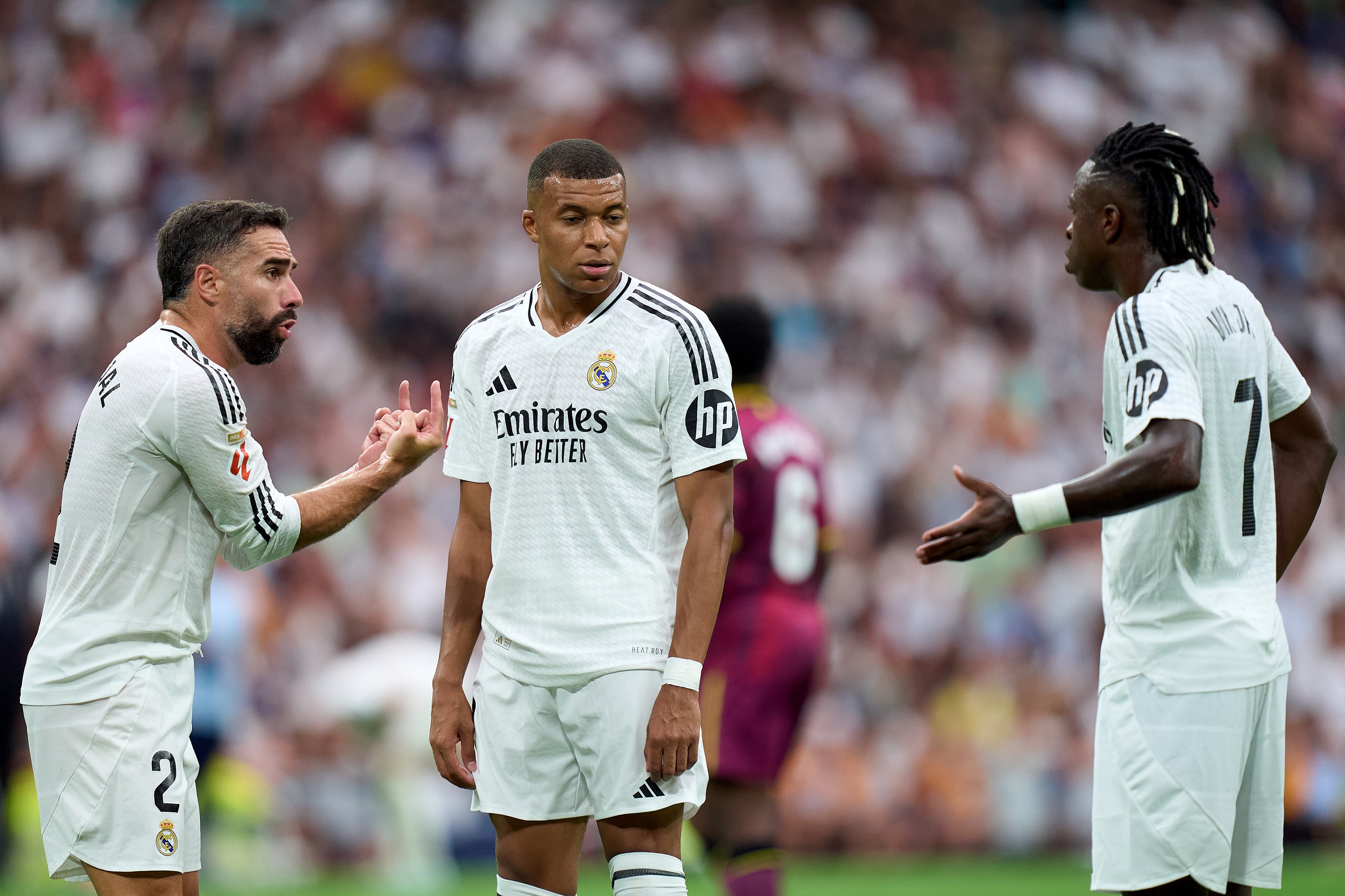 MADRID, SPAIN - AUGUST 25: Daniel Carvajal of Real Madrid interacts with his teammates Kylian Mbappe and Vinicius Junior during the La Liga match between Real Madrid CF and Real Valladolid CF at Estadio Santiago Bernabeu on August 25, 2024 in Madrid, Spain.