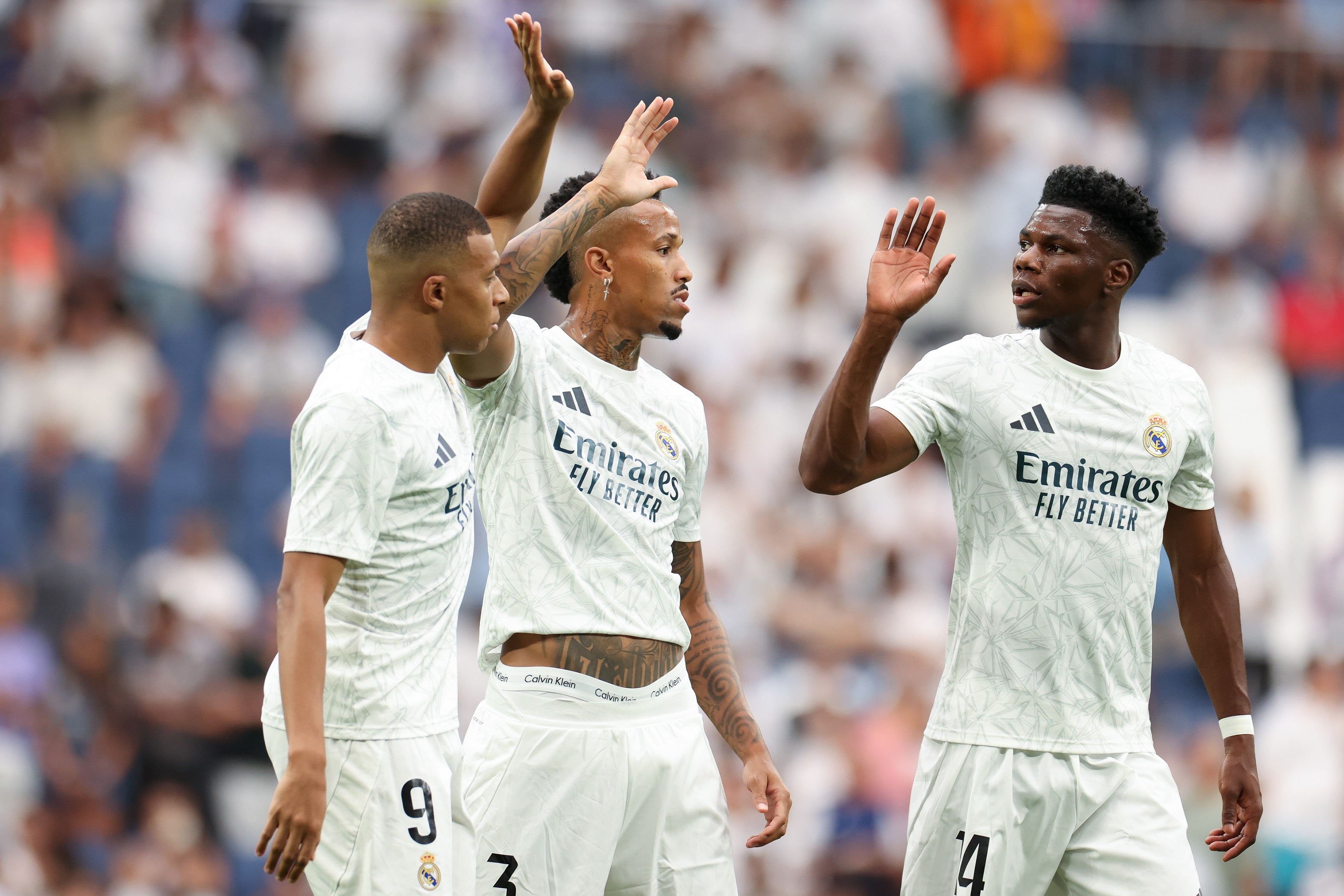 MADRID, SPAIN - AUGUST 25: Kylian Mbappe of Real Madrid CF interacts with teammates Eder Militao and Aurelien Tchouameni during the La Liga match between Real Madrid CF and Real Valladolid CF at Estadio Santiago Bernabeu on August 25, 2024 in Madrid, Spain.