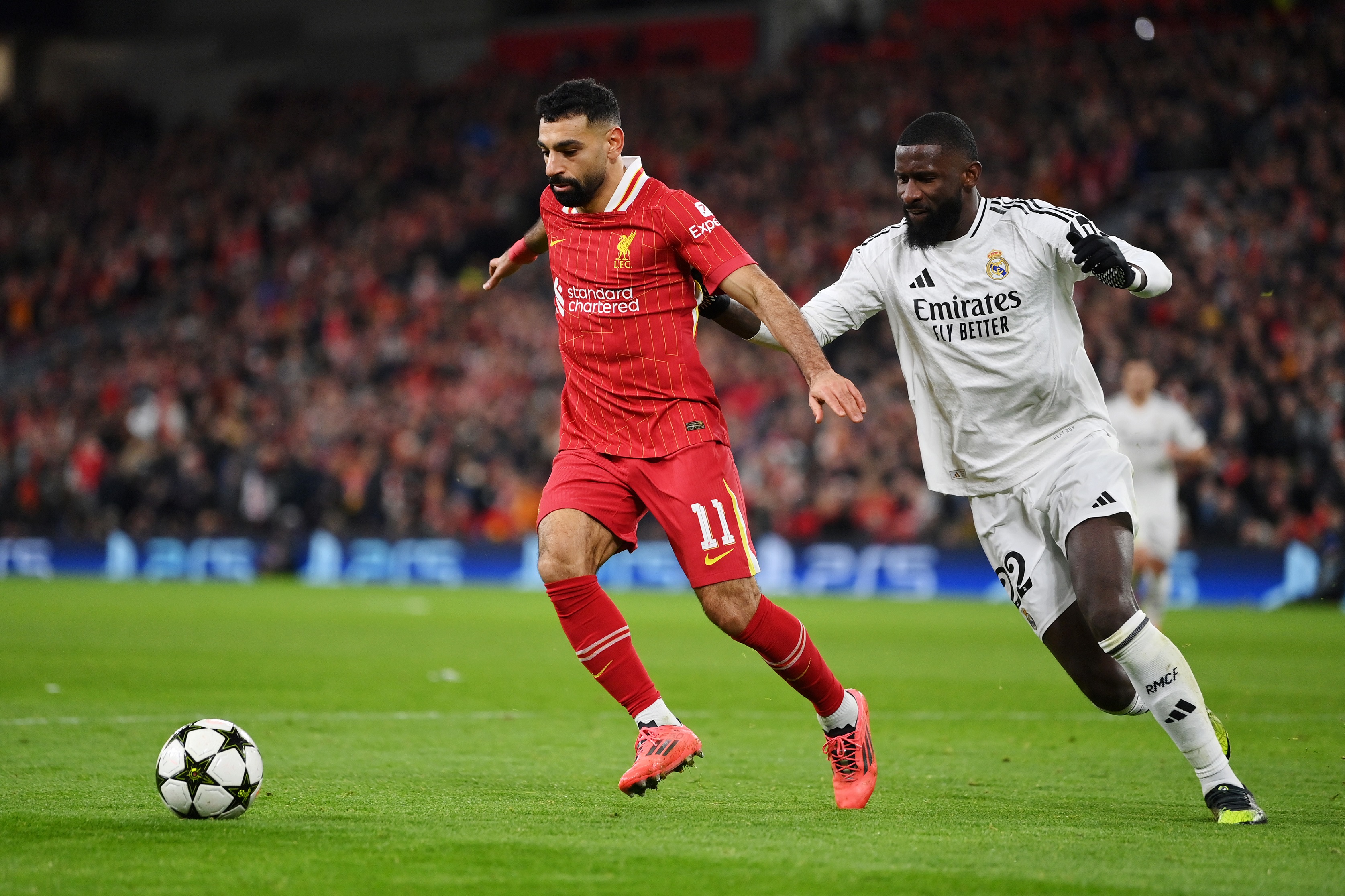 LIVERPOOL, ENGLAND - NOVEMBER 27: Mohamed Salah of Liverpool runs with the ball under pressure from Antonio Ruediger of Real Madrid during the UEFA Champions League 2024/25 League Phase MD5 match between Liverpool FC and Real Madrid C.F. at Anfield on November 27, 2024 in Liverpool, England.