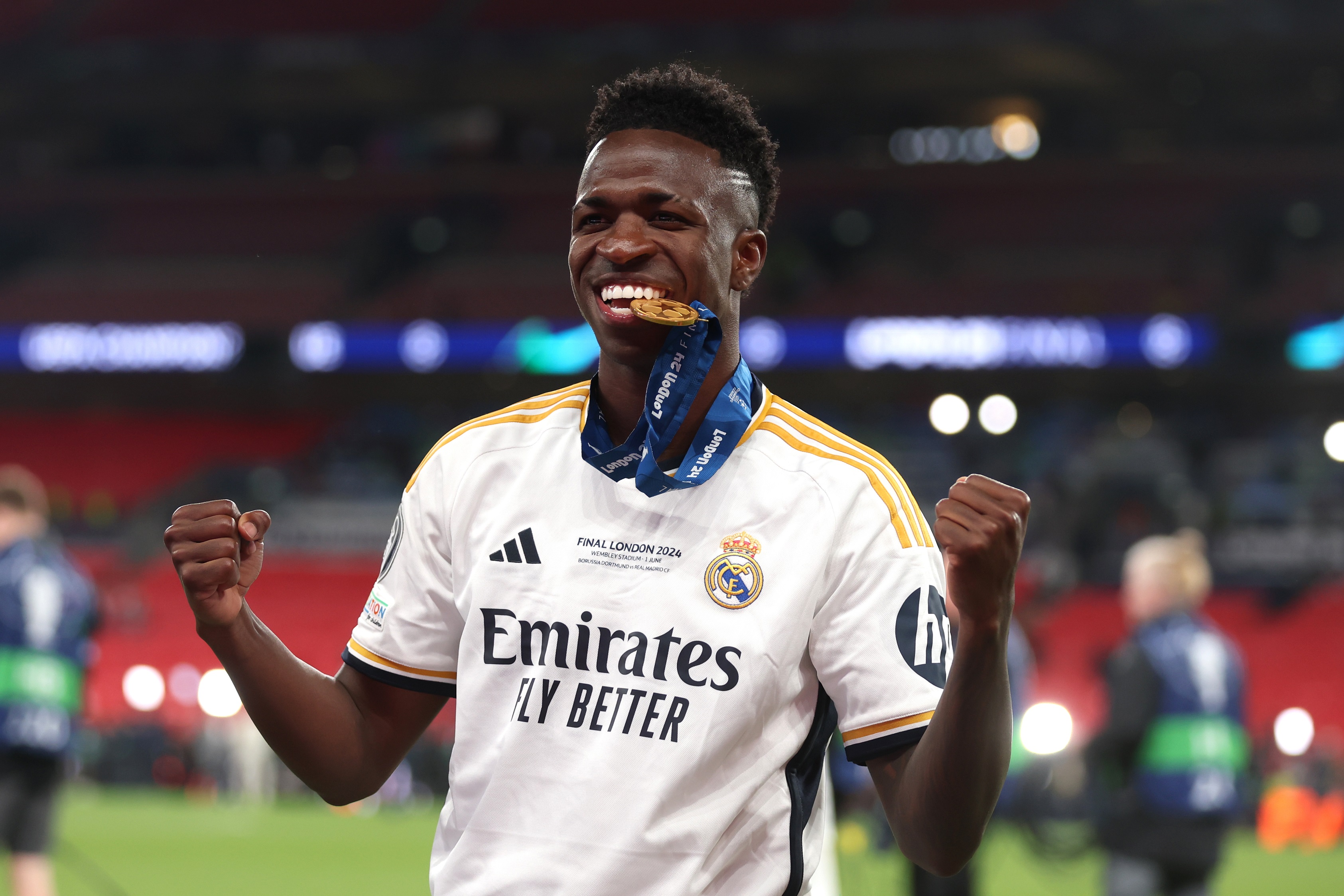 LONDON, ENGLAND - JUNE 01: Vinicius Junior of Real Madrid bites his winners medal following victory in the UEFA Champions League 2023/24 Final match between Borussia Dortmund and Real Madrid CF at Wembley Stadium on June 01, 2024 in London, England.