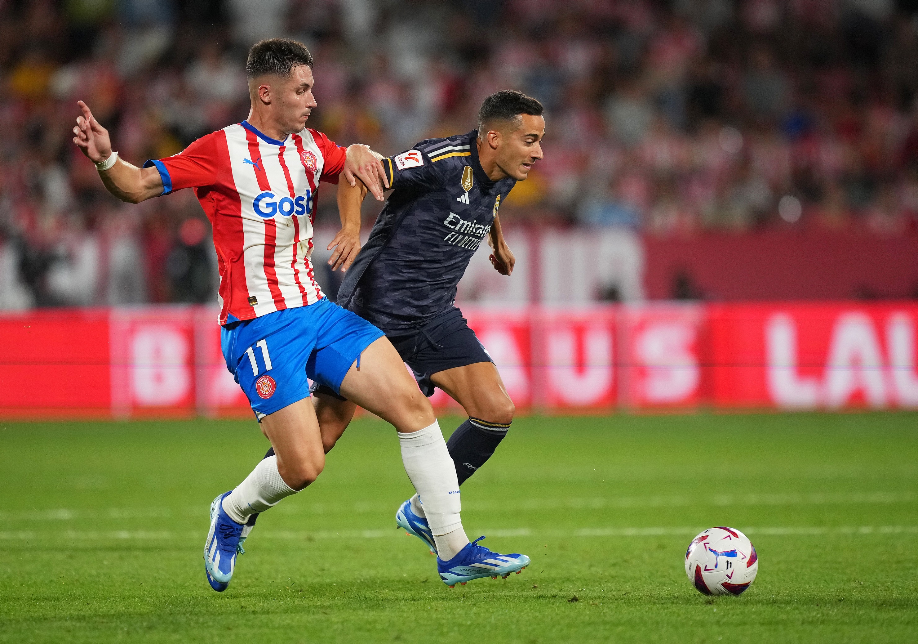 GIRONA, SPAIN - SEPTEMBER 30: Valery Fernandez of Girona battles for possession with Lucas Vazquez of Real Madrid during the LaLiga EA Sports match between Girona FC and Real Madrid CF at Montilivi Stadium on September 30, 2023 in Girona, Spain.