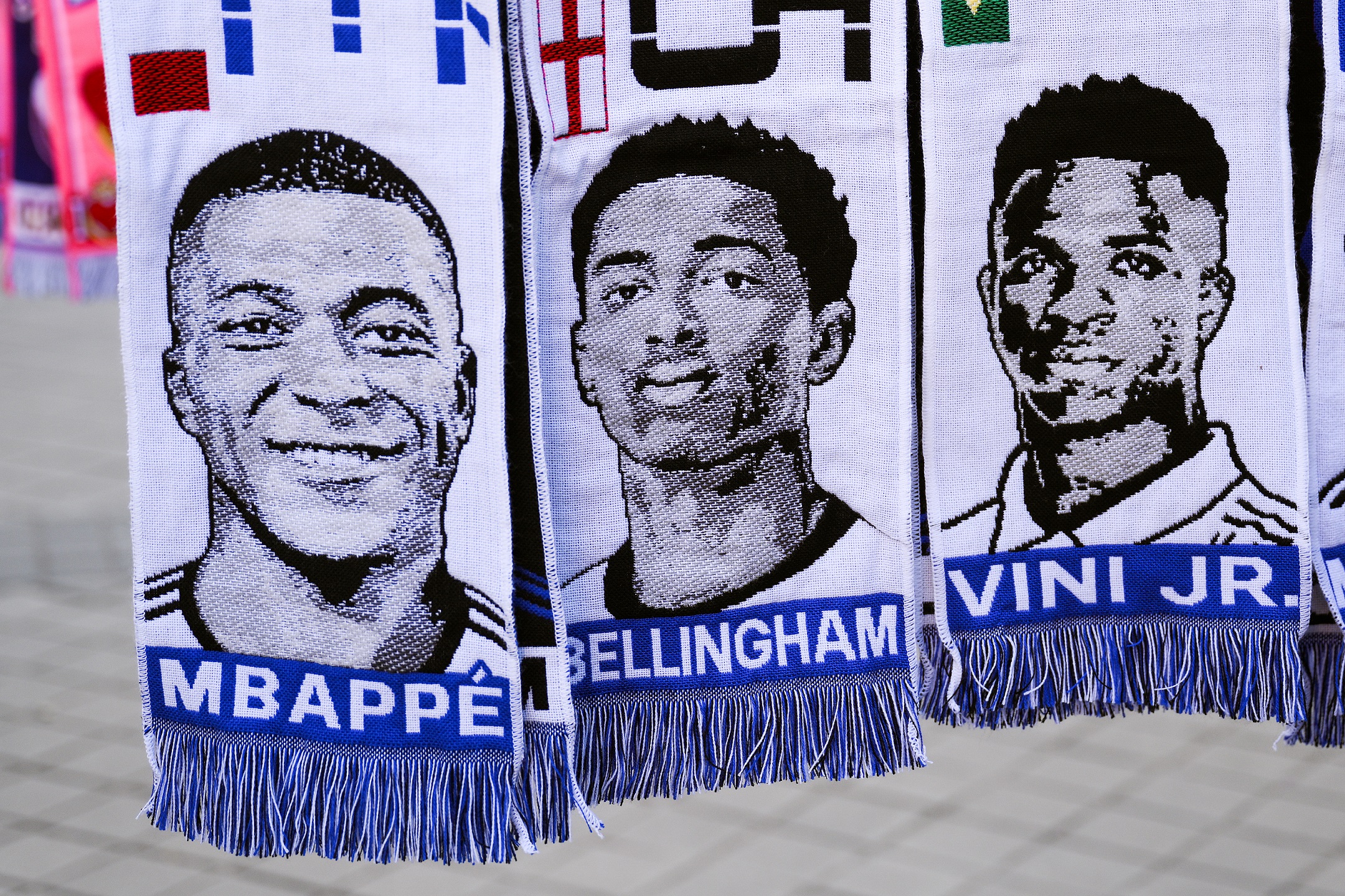 MADRID, SPAIN - MARCH 06: Scarves of Kylian Mbappe, Jude Bellingham and Vinicius Jr.hang in a souvenir stall outside the stadium prior to the UEFA Champions League 2023/24 round of 16 second leg match between Real Madrid CF and RB Leipzig at Estadio Santiago Bernabeu on March 06, 2024 in Madrid, Spain.