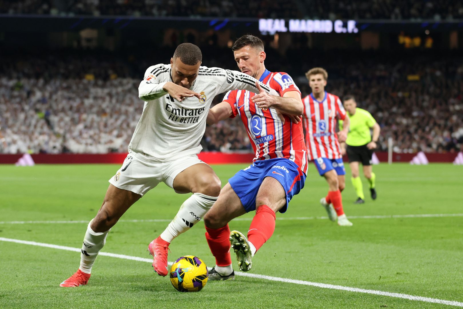 MADRID, SPAIN - FEBRUARY 08: Kylian Mbappe of Real Madrid is challenged by Clement Lenglet of Atletico de Madrid during the LaLiga match between Real Madrid CF and Atletico de Madrid at Estadio Santiago Bernabeu on February 08, 2025 in Madrid, Spain.