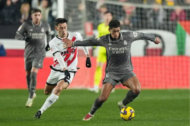 MADRID, SPAIN - DECEMBER 14: Jude Bellingham of Real Madrid controls the ball under pressure from Pedro Diaz of Rayo Vallecano during the LaLiga EA Sports match between Rayo Vallecano and Real Madrid at Estadio de Vallecas on December 14, 2024 in Madrid, Spain.