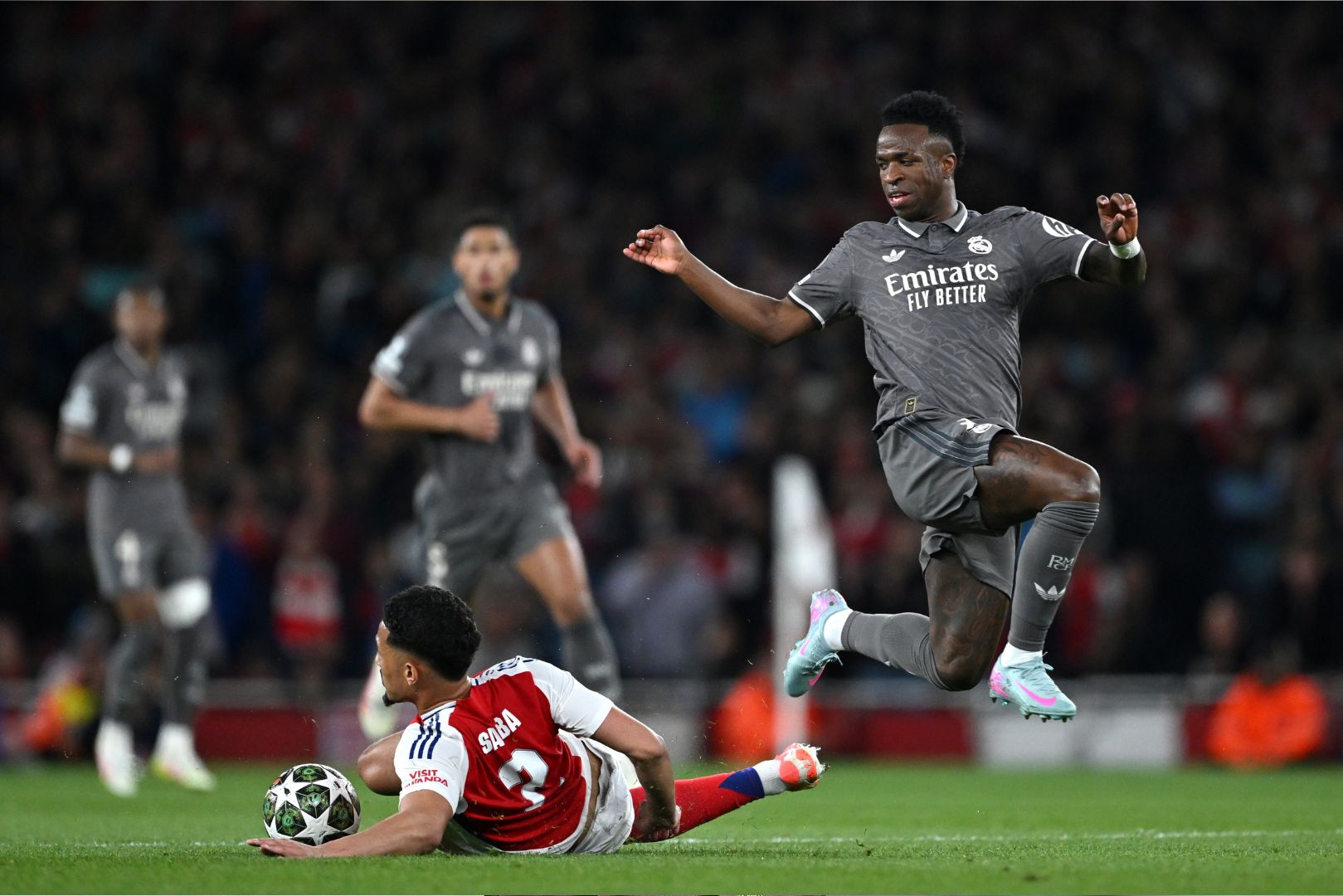 ONDON, ENGLAND - APRIL 08: William Saliba of Arsenal makes a tackle on Vinicius Junior of Real Madrid during the UEFA Champions League 2024/25 Quarter Final First Leg match between Arsenal FC and Real Madrid C.F. at Emirates Stadium on April 08, 2025 in London, England.