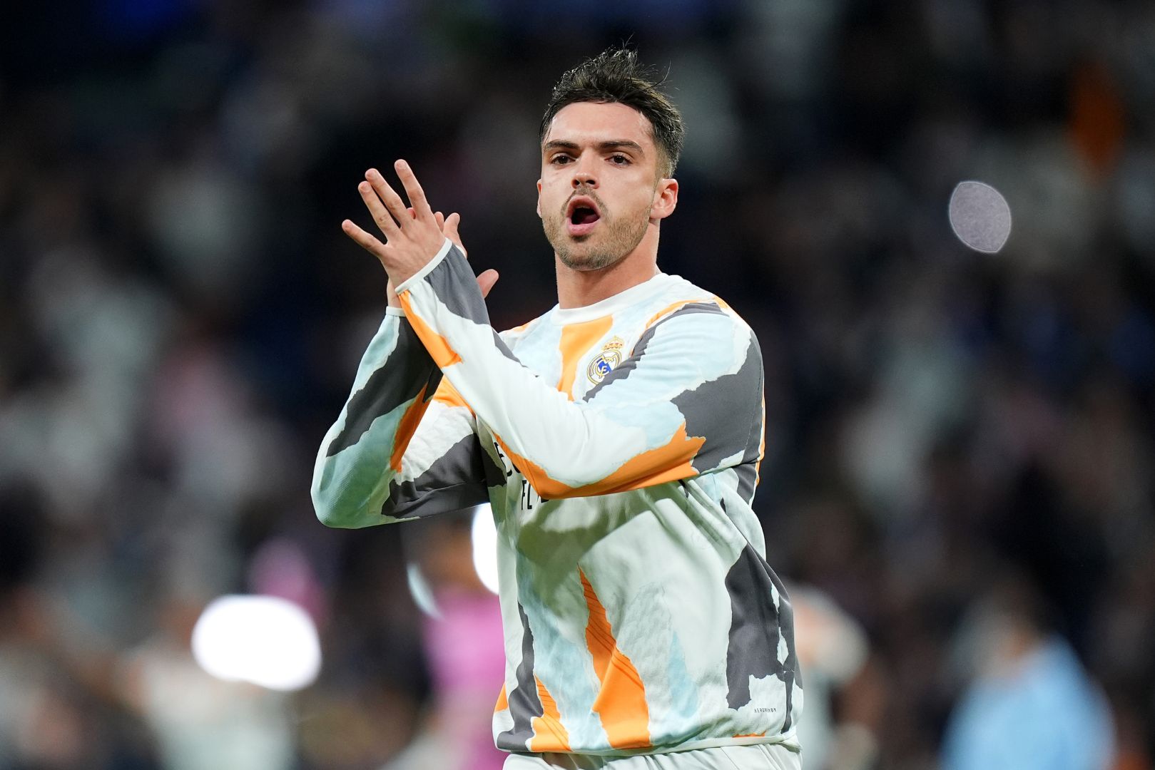 MADRID, SPAIN - APRIL 16: Raul Asencio of Real Madrid applauds the fans as he warms up prior to the UEFA Champions League 2024/25 Quarter Final Second Leg match between Real Madrid C.F. and Arsenal FC at Estadio Santiago Bernabeu on April 16, 2025 in Madrid, Spain.