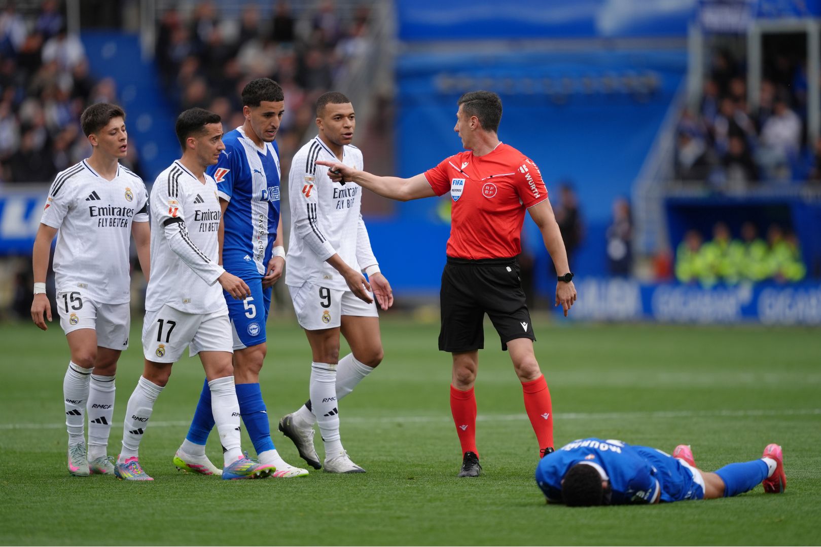 VITORIA-GASTEIZ, SPAIN - APRIL 13: 12 Kylian Mbappe of Real Madrid speaks to referee Cesar Soto Grado as Santiago Mourino of Deportivo Alaves lays on the floor during the LaLiga match between Deportivo Alaves and Real Madrid CF at Estadio de Mendizorroza on April 13, 2025 in Vitoria-Gasteiz, Spain.