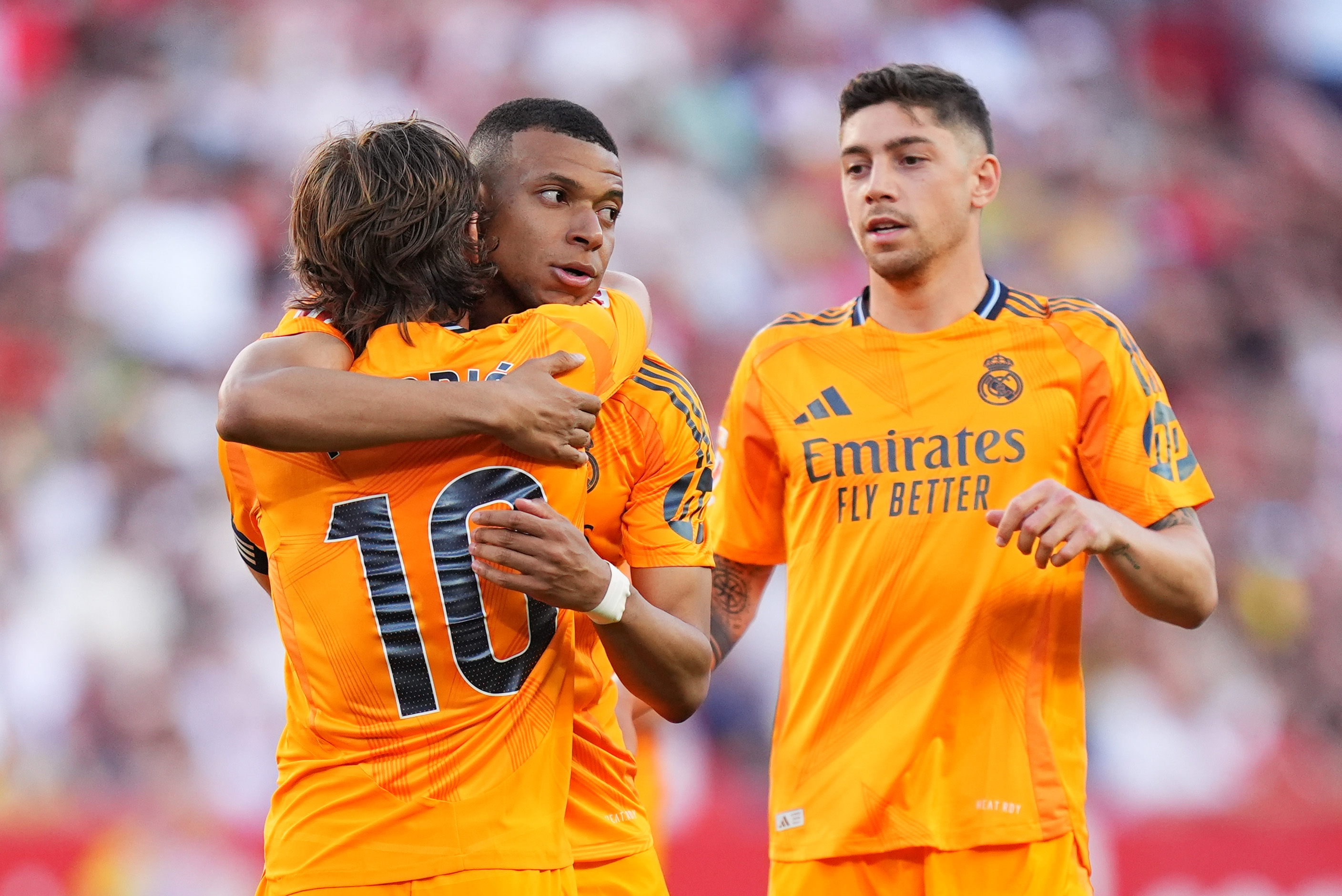 SEVILLE, SPAIN - MAY 18: Kylian Mbappe of Real Madrid celebrates scoring his team's first goal with teammates Luka Modric and Federico Valverde during the LaLiga match between Sevilla FC and Real Madrid CF at Estadio Ramon Sanchez Pizjuan on May 18, 2025 in Seville, Spain.